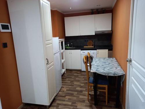 a small kitchen with a table and a table and chairs at chambre très confortable et acclimatée in Audun-le-Tiche