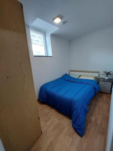 - une chambre avec un lit bleu dans l'établissement chambre très confortable et acclimatée, à Audun-le-Tiche