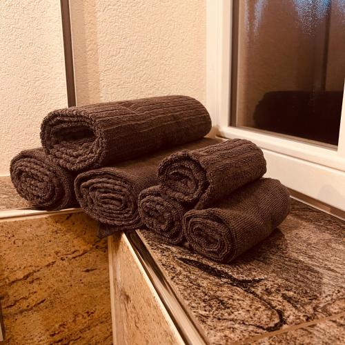 a pile of towels on a counter in front of a mirror at Rose Boardinghouse 24h-7d Self Check-In Automat in Großbottwar