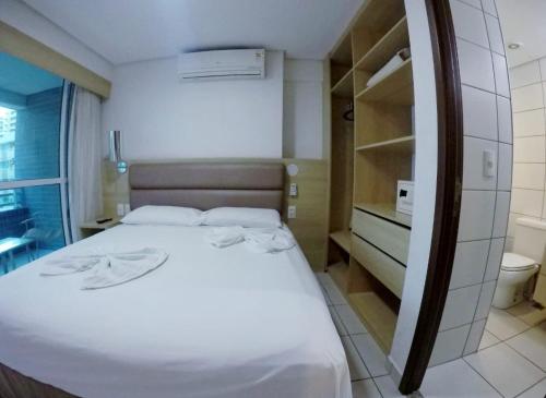 een kleine slaapkamer met een bed en een badkamer bij Beach Class by Solemar in Fortaleza