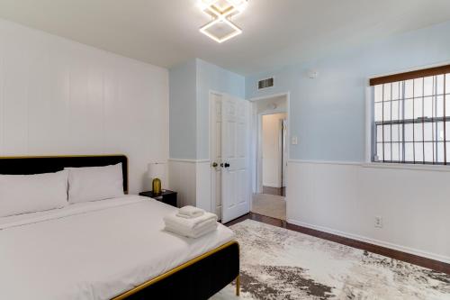 a white bedroom with a bed and a window at 5 Bedroom Charmer with Pool in Reseda