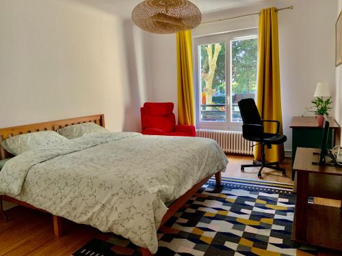een slaapkamer met een bed, een stoel en een raam bij GRAND Appartement 85m2 centre ville de BIARRITZ 6 pers in Biarritz
