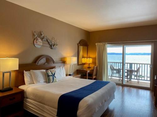 a hotel room with a bed and a balcony at The Waterfront at Potlatch in Shelton
