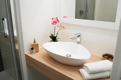 La salle de bains est pourvue d'un lavabo blanc sur un comptoir en bois. dans l'établissement Toscano Palace Luxury Rooms Catania, à Catane