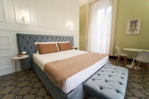 a bedroom with a large bed and a table at Toscano Palace Luxury Rooms Catania in Catania