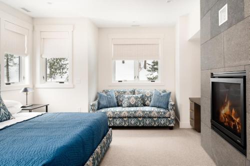 1 dormitorio con cama, sofá y chimenea en Spanish Peaks - Highlands Cabin 19, en Big Sky