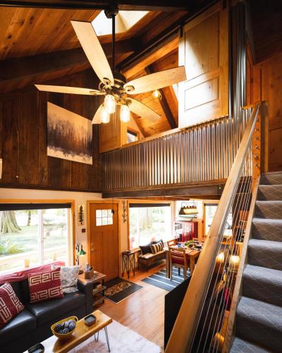 a living room with a ceiling fan and a staircase at On Mountain Time in Glacier