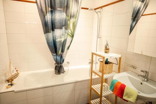 ein Badezimmer mit einer Badewanne und einem Waschbecken in der Unterkunft Apartments am See in Brienz