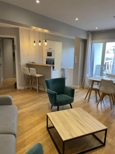 un salon avec une chaise et une table ainsi qu'une cuisine dans l'établissement Appartement Roland-Gaross/Boulogne-Billancourt, à Boulogne-Billancourt