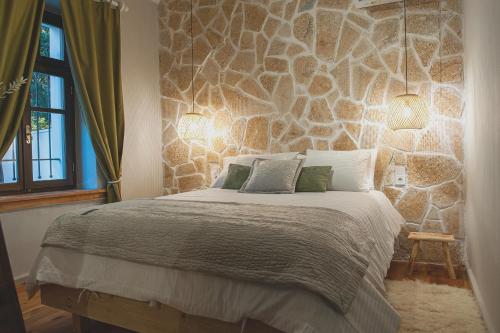 una camera da letto con un grande letto e un muro in pietra di locanta a Ioannina