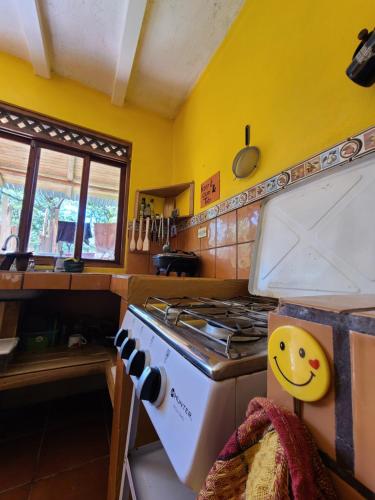 a kitchen with a stove and a yellow wall at Casa Terra in Sámara