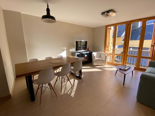 uma sala de estar com uma mesa de madeira e cadeiras em Apartamento Casa Francho 2 em Panticosa
