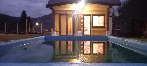 a small house in a pool of water at night at VIKENDICA NOLE Jahorina in Pale