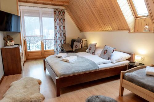 a bedroom with a bed and a large window at Bylinkowa Chata Jacuzzi & Sauna in Poronin