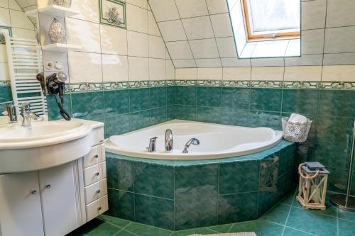 La salle de bains est pourvue d'une baignoire et d'un lavabo. dans l'établissement Bylinkowa Chata Jacuzzi & Sauna, à Poronin