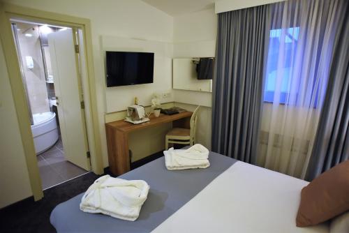 a hotel room with two white towels on a bed at Hotel Santiny in Sveta Nedelja