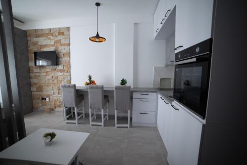 a kitchen with white cabinets and a table with chairs at NLux 11 Apartment in Kopaonik