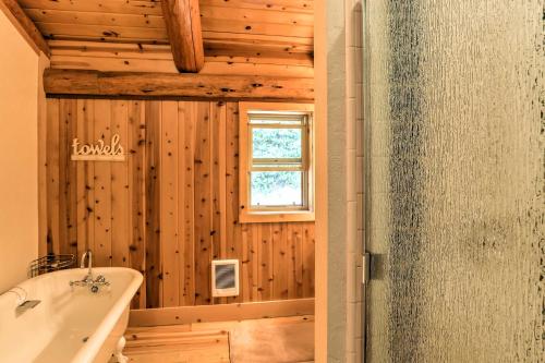 a wooden bathroom with a tub and a window at Log Home on 40 Private Acres By Mt Shasta Ski Park in McCloud