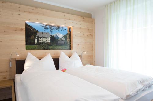 2 witte bedden in een slaapkamer met een raam bij Alpenblick Nr 2 in Campo Tures