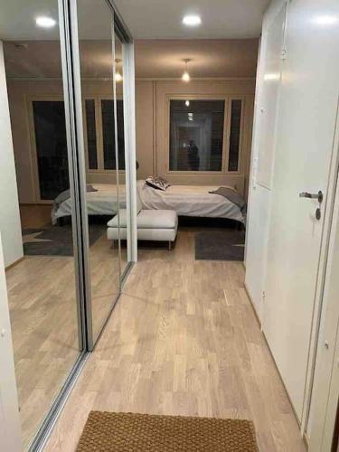 Habitación con dormitorio con cama y espejo. en City apartment nearby Airport, en Vantaa