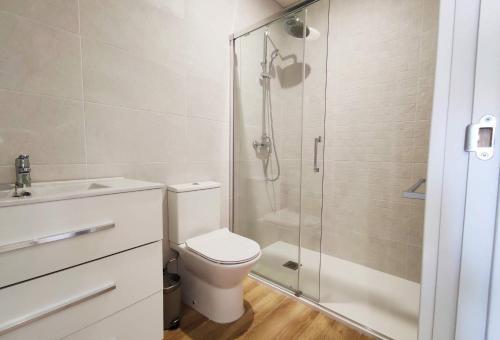 een badkamer met een toilet en een glazen douche bij APARTAMENTOS SANLUCAR CASA C in Sanlúcar de Barrameda