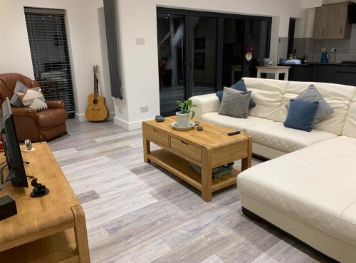 a living room with two couches and a coffee table at Surfers Lodge - Rest Bay, Porthcawl in Porthcawl