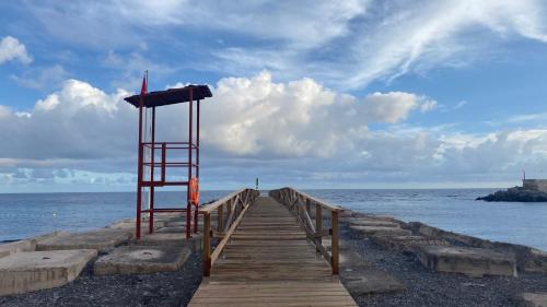 a lifeguard tower on a wooden bridge over the ocean at Casa Moni con Vistas al Mar in Playa de Santiago