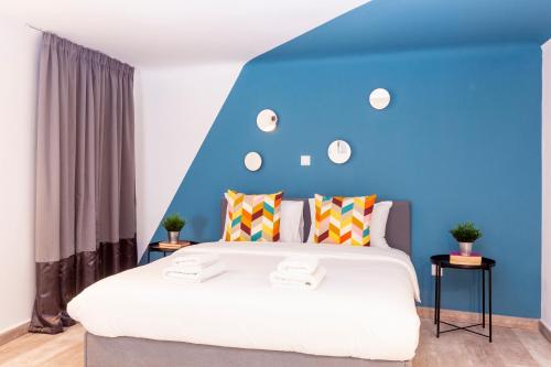 a bedroom with a large bed with a blue headboard at Psirri Lofts in Athens
