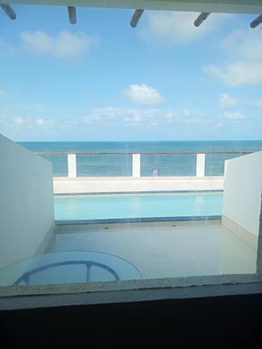 a view of the ocean from a balcony with a swimming pool at La Suite Praia Hotel in Caucaia