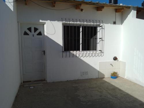 - un bâtiment blanc avec un portail et une porte dans l'établissement Alquiler por día Choele Choel 1, à Choele Choel