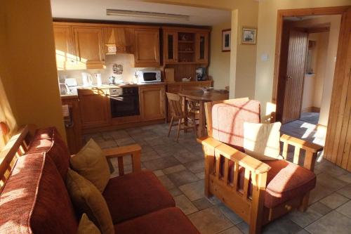 un soggiorno con divano e cucina di Barnwell Farm Cottages Corn cottage a Greyabbey