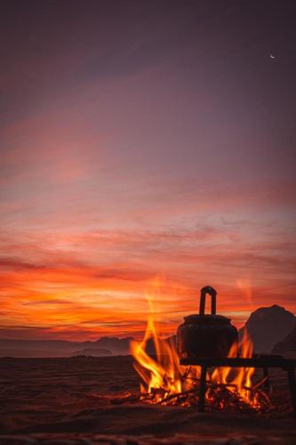 a camp fire with a pot on top of it at RUM STARDUST lUXURY CAMP in Wadi Rum