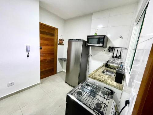 una pequeña cocina con fregadero y nevera. en Expo Center - Apartamento Vila Maria - São Paulo, en São Paulo