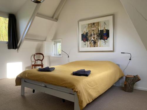 een slaapkamer met een bed met een gele deken bij Landhuis 'De Ontspanning' in Axel
