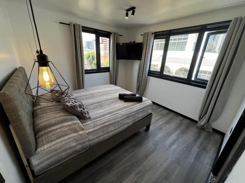 sala de estar con sofá y 2 ventanas en VOY Hostales - Oriente en Viña del Mar