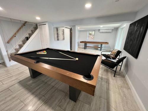 a billiard room with a pool table and a staircase at Cozy Cabin on the Lake w/ HotTub in Hopatcong