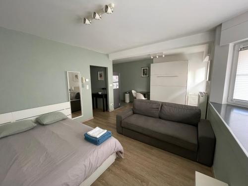 a bedroom with a bed and a couch at Studio close from train station and shops in Luxembourg