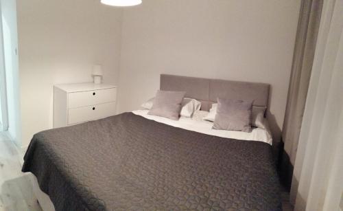 sypialnia z dużym łóżkiem i białą komodą w obiekcie Apartament MajaHouse w Nowej Soli