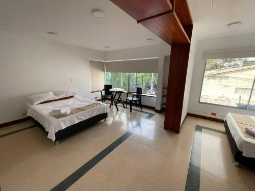 um quarto com uma cama, uma mesa e cadeiras em Apartamento privado en Medellin MAG301 em Medellín