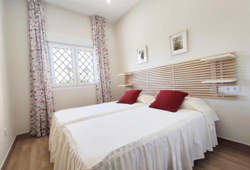 1 dormitorio con 2 camas y ventana en APARTAMENTOS SANLUCAR CASA D, en Sanlúcar de Barrameda