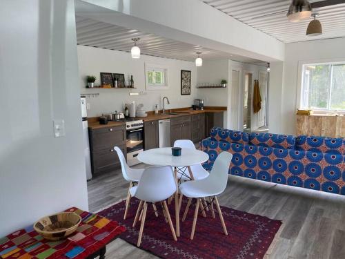 eine Küche und ein Wohnzimmer mit einem Tisch und Stühlen in der Unterkunft Ski Hike Swim Container Cabin in Rumney
