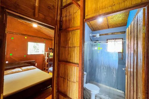 um pequeno quarto com uma cama e um banheiro em Cambuca Surf Skate em Ubatuba