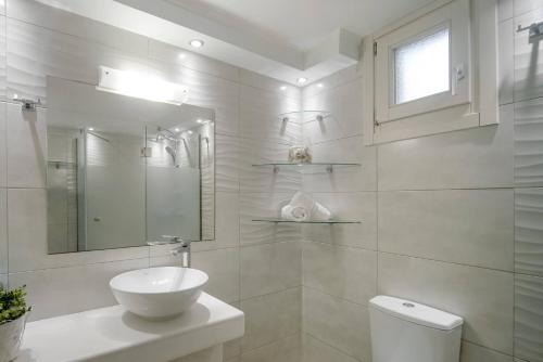 a white bathroom with a sink and a toilet at Loggos View House in Mastorátika