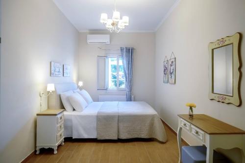 una camera con letto, scrivania e specchio di Loggos View House a Mastorátika