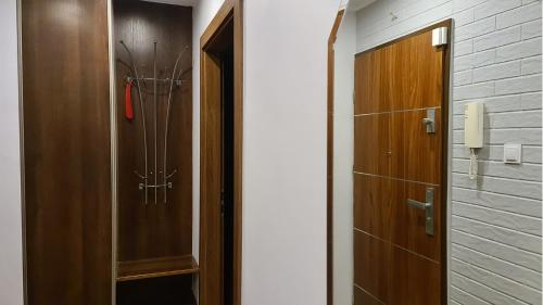 a hallway with a wooden cabinet and a door at Spokojny Wypoczynek 4 in Ostrów Wielkopolski