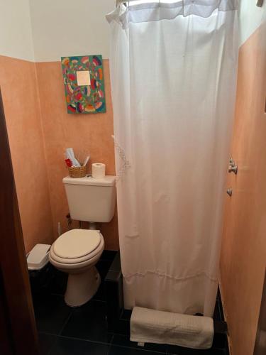 y baño con aseo y cortina de ducha. en Apartamento Justina en La Cumbre