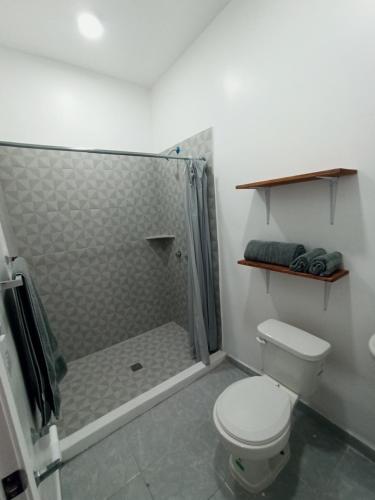 a bathroom with a toilet and a shower with a shower curtain at Your Bedroom in Puerto Peñasco