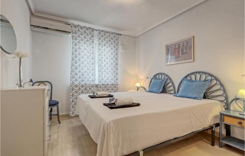ein Schlafzimmer mit einem großen weißen Bett mit blauen Kissen in der Unterkunft Stunning Home In Gran Alacant With Outdoor Swimming Pool in Santa Pola