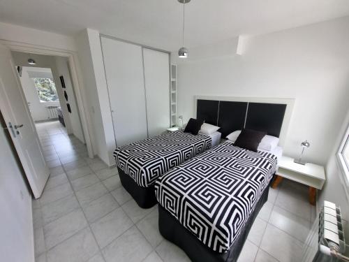 聖卡洛斯－德巴里洛切的住宿－Bariloche Modern Apartment Belgrano，一间带两张床的卧室和走廊