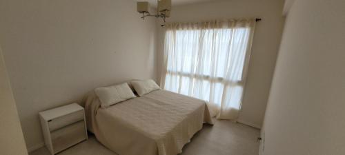 Habitación pequeña con cama y ventana en Ramallo Departamento en Ramallo